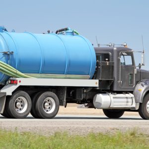 Side view of a pump truck hauling sewage removed from a residential septic tank.