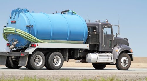 Side view of a pump truck hauling sewage removed from a residential septic tank.