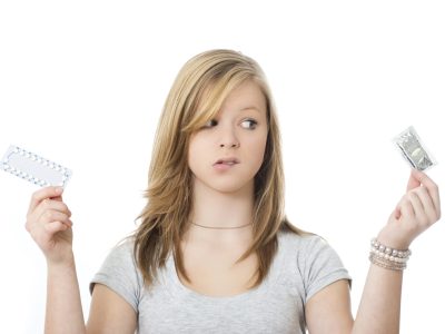A woman choosing between birth control methods Young girl isolated on white