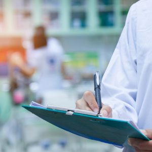 Doctor writing a medical prescription in hospital