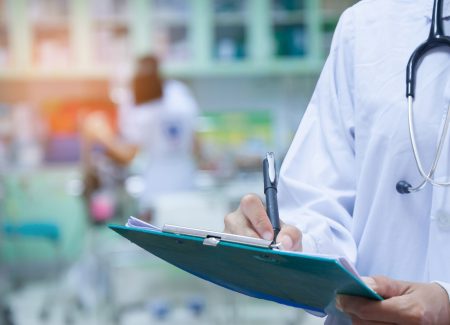 Doctor writing a medical prescription in hospital Doctor writing a medical prescription in hospital